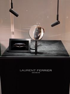 a display case with three lights and a cell phone on it's stand in front of a wall