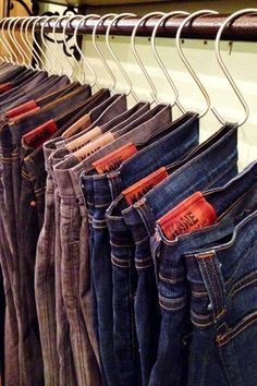 several pairs of jeans hanging on a rail