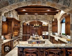 a large kitchen with wooden cabinets and marble counter tops, along with an archway leading to the dining room