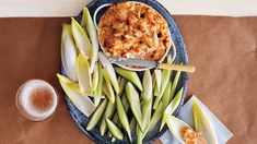 a blue plate topped with green beans and macaroni next to a glass of beer