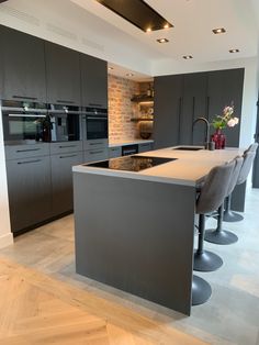 a modern kitchen with an island in the middle and stainless steel appliances on either side