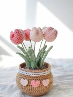 crocheted flowers in a pot with hearts on the bottom and one flower sticking out of it