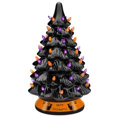 a small black christmas tree with orange and purple lights on it's base,