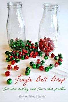 two glass jars filled with red and green candies on top of a white table