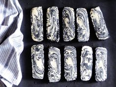 six pieces of cake sitting on top of a black tablecloth next to a white towel