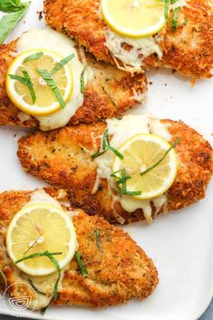 chicken schnitz with lemons and herbs on a white platter, ready to be eaten