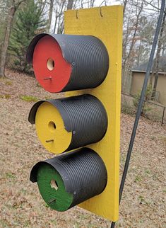 a traffic light made out of tin canisters on a pole in the woods