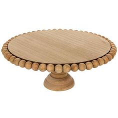 a round wooden cake plate with beaded edges