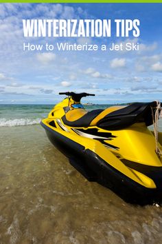 a yellow and black jet ski sitting on top of a beach next to the ocean