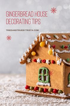 a gingerbread house decorated with icing and christmas decorations on top of a table