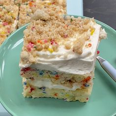 a piece of cake with white frosting and sprinkles on a plate