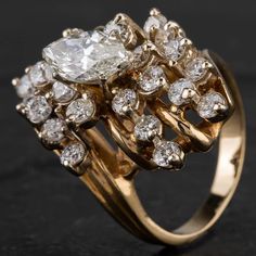 a gold ring with two rows of diamonds on top and an oval shaped diamond in the middle