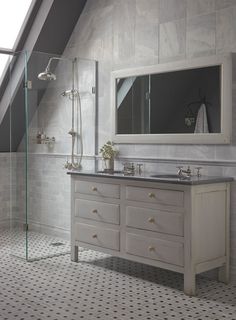 a white bathroom with a skylight above the sink and shower area, along with a chair