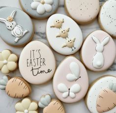 decorated cookies are arranged on a marble surface with the words it's easter time