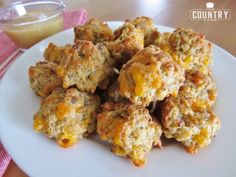 a white plate topped with cheesy biscuits next to a glass of orange juice