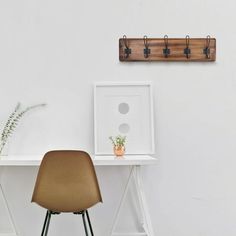 a chair sitting in front of a white desk with a plant on top of it