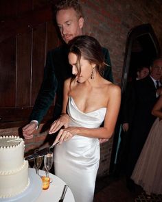 a bride and groom cutting their wedding cake