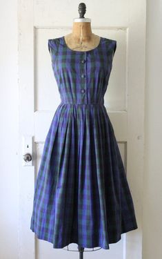 Classic vintage 1950s navy and dark green plaid cotton jumper dress. Made of a soft cotton with a polka dot pattern woven into the textile. Featuring a scoop neckline, functional fabric covered buttons down the front, fitted waist, and full pleated skirt. Has a metal side zipper and belt loops. Would look great styled with a long sleeve blouse beneath. ☾ Info ☽ Material: cotton Label: A David Crystal Fashion Condition: very good vintage condition; I've repaired a 1" rip at the back of the neck and a pea sized rip near the left underarm Freshly laundered and ready to wear! ☾ Measurements ☽ Fits like: small Bust: 34" (can stretch to 35") Waist: 26" Hips: free Length (from shoulder): 45" Bodice length (from shoulder): 16"  *shown unpinned on a 33" bust, 25" waist dress form  ☾ More vintage dr Knee-length Cotton Plaid Dress For Daywear, Retro Gingham Plaid Cotton Dress, Cotton Plaid Dress With Buttons For Daywear, Retro Cotton Plaid Dress, Retro Plaid Cotton Dress, Cotton Vintage Dress With Buttons, Vintage A-line Plaid Dress, Vintage Cotton Dress With Buttons, Fitted Cotton Gingham Vintage Dress