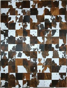 a brown and white checkered pattern with black spots on the top, in an area that looks like it has been made out of cow hides