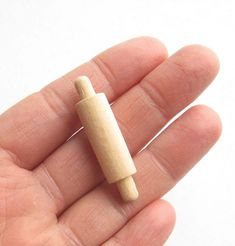 a tiny wooden object in the palm of someone's hand