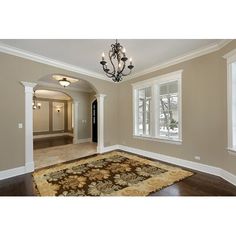 an empty living room with carpet and chandelier