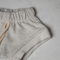 Help your little one stay cool and comfortable with our lightweight, breathable short sweat shorts. Crafted from a soft blend of materials, these shorts feature a convenient drawstring for an adjustable fit and a light heathered grey for an effortless, stylish look. These snug sweat shorts are perfect for any season. Sock Booties, Swim Sets, One Piece Swim, Sweat Shorts, Knit Sweatshirt, Stay Cool, Beanie Hats, Short Pants, Unisex Clothing