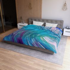 a bed with a blue and purple comforter on top of it in a bedroom