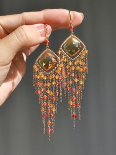 This is a pair of exquisite natural Citrine, and I have crafted exquisite frames for them. I have used high-quality Fanta garnet, Padparadscha sapphire, and red spinel to create tassels, which shine brilliantly in the sunlight, like a romantic sunset. ●Citrine ●Fanta garnet ●Padparadscha sapphire ●red spinel ●14k gold filled ●total length approximately: 3.89 inches ●weight：6.5g Welcome to visit my Jewelry store: https://www.etsy.com/shop/Ukuly 🌸The delivery time to Most regions of North America, Australia and Europe is usually about 10-15 days. Buyers from Brazil, South Korea, and Indonesia, please provide me with your tax number through messages or notes for smooth shipment. Thank you. 🌸Please let me know your phone number when you place an order. It will be used for shipping label only Orange Gemstone Dangle Earrings, Elegant Orange Earrings With Natural Stones, Orange Gemstone Dangle Jewelry, Fusion Style Chandelier Earrings With Dangling Beads, Elegant Orange Chandelier Earrings For Gift, Elegant Orange Chandelier Earrings Gift, Fusion Style Dangling Beads Chandelier Earrings For Gift, Orange Dangle Earrings With Natural Stones, Orange Fine Jewelry With Matching Earrings