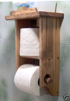 a wooden shelf holding two rolls of toilet paper