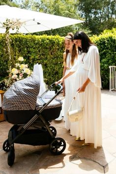 two women are standing next to a baby carriage