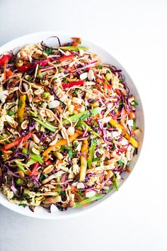 a white bowl filled with colorful vegetables on top of a table