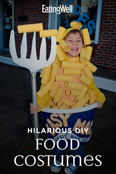 a young boy in a costume made out of food is holding a pitchfork and smiling