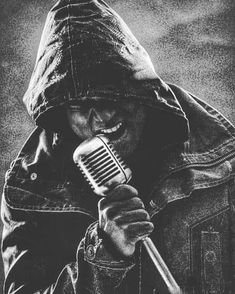 a black and white photo of a man holding a microphone in his hand, wearing a hoodie