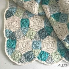 a crocheted blanket is laying on top of a white wall and it looks like hexagonal shapes