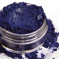 a jar filled with blue glitter sitting on top of a table