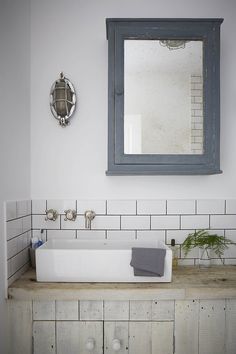 a white sink sitting under a mirror in a bathroom