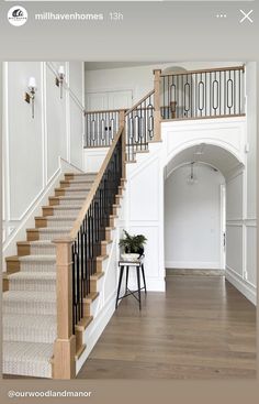 the stairs in this house are made of wood and wrought iron railings, along with white walls