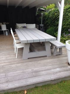 a white table and chairs on a wooden deck