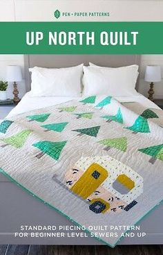 a bed with a quilt on top of it and the words up north quilt written in green