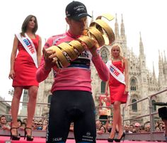 a man is holding some bread in his hands while other people stand behind him and look on