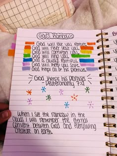 a hand holding a notebook with writing on it and an image of a rainbow cross