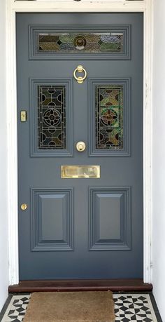 the front door is painted blue and has two glass panels on it, along with a rug