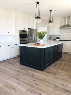 a kitchen with white cabinets and black island