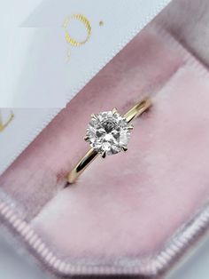 an engagement ring in a pink velvet box