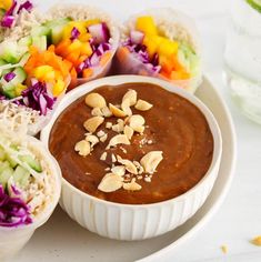 a white plate topped with lots of food next to bowls filled with different types of salads