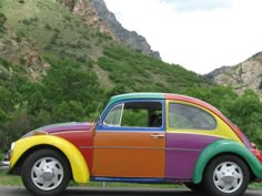 a multicolored beetle parked in front of a mountain