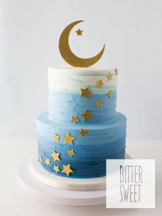 a blue cake with gold stars and a crescent on top is sitting on a white plate