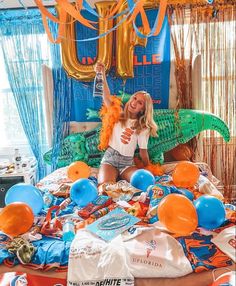 a woman sitting on top of a bed surrounded by balloons