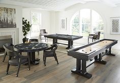 a living room filled with furniture and a pool table in front of a fire place