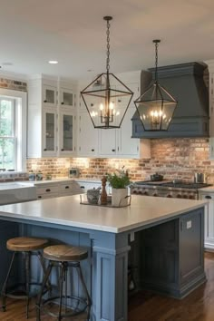 a kitchen with an island and two stools in front of the countertop area